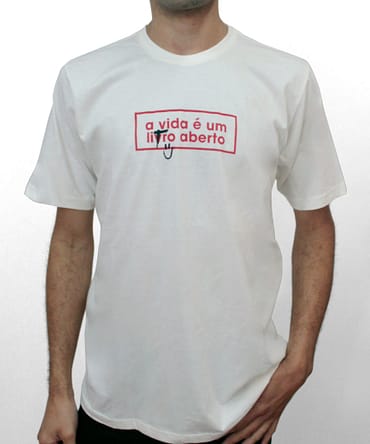 Camiseta com fundo branco e escrita em vermelho que diz: "A vida é um livro aberto"