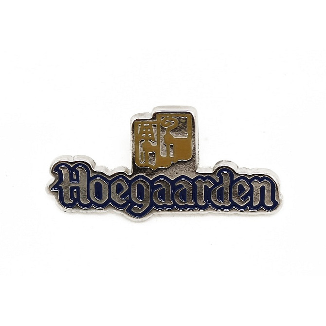 Pin metálico em formato do texto escrito "Hoegaarden" em prata e contorno azul.